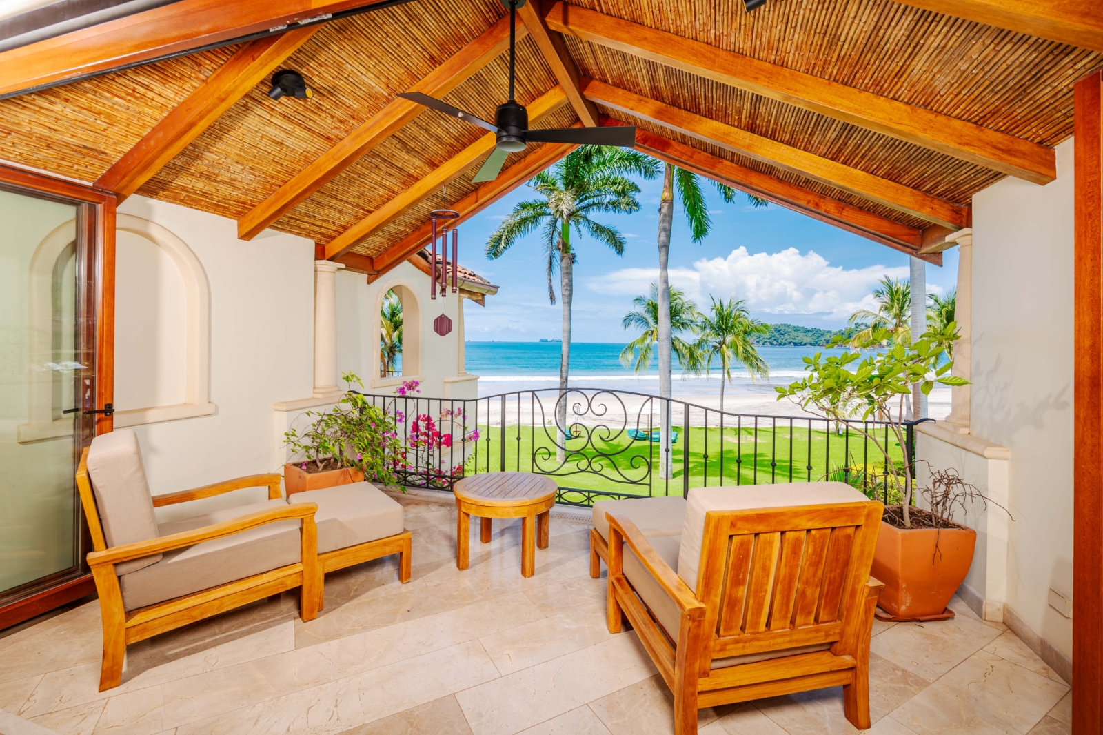 Covered balcony with wood ceiling and lounge seating overlooking Playa Flamingo in Costa Rica – Charity Ace auction trip