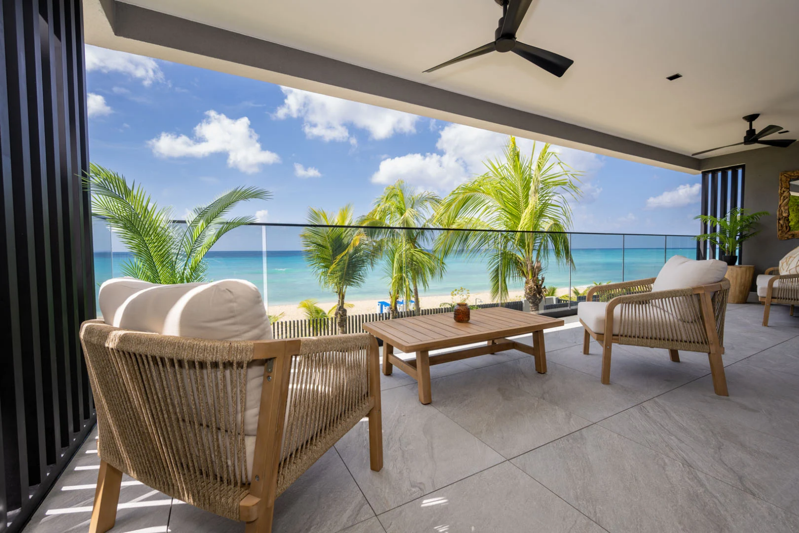 Spacious beachfront balcony with plush seating and stunning views of the turquoise Caribbean Sea in Barbados