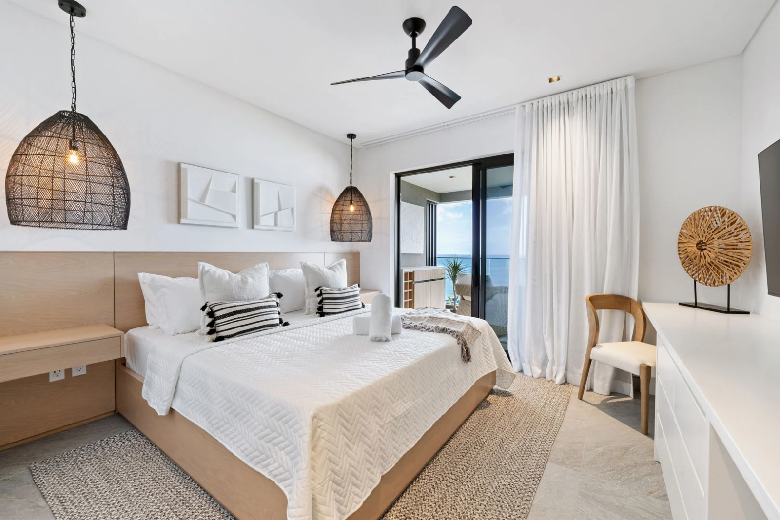 Modern master bedroom in Barbados with balcony access and ocean view in luxury beachfront apartment