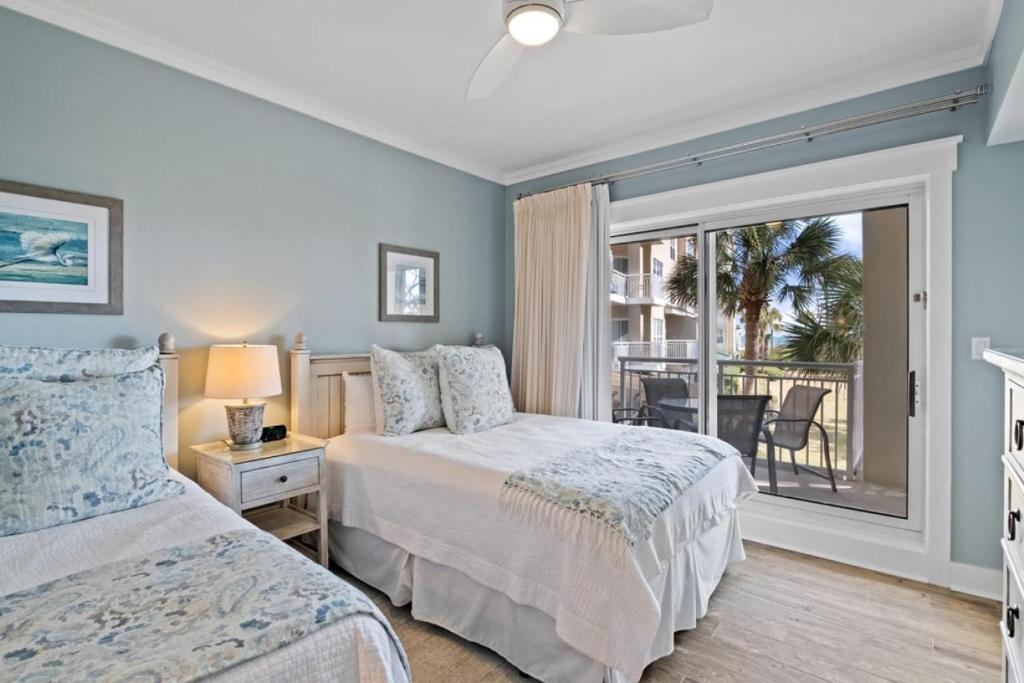 Guest bedroom with two beds and ocean-view balcony at luxury Hilton Head resort