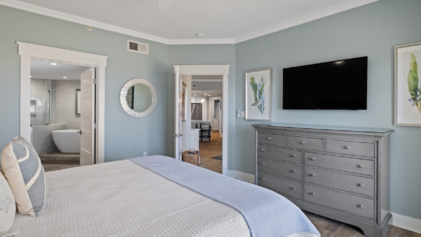 Coastal-themed master bedroom with flat-screen TV, ensuite bath, and serene decor in Hilton Head villa