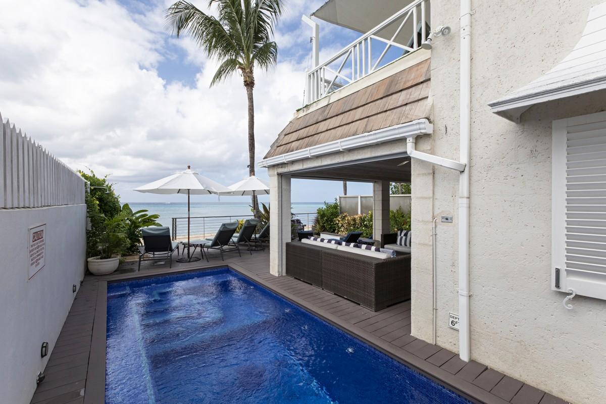 Private plunge pool and shaded lounge deck with ocean views at a luxury Barbados beachfront villa