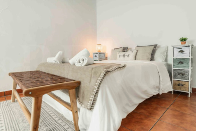 Serene master bedroom with soft linens, neutral tones, and artisan décor in a luxury Malaga accommodation for Charity Ace travelers.