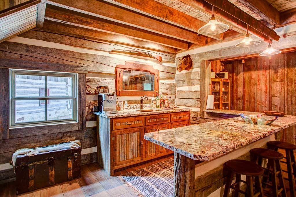Rustic log cabin interior featuring a granite kitchen bar, wooden cabinetry, and vintage décor